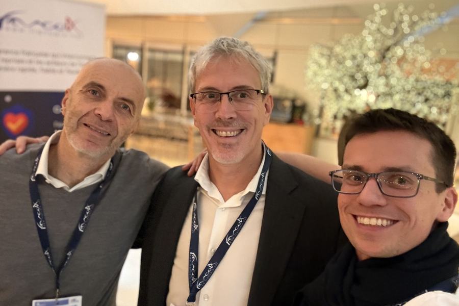 Trois personnes portant des badges posent pour un selfie lors d’un événement.