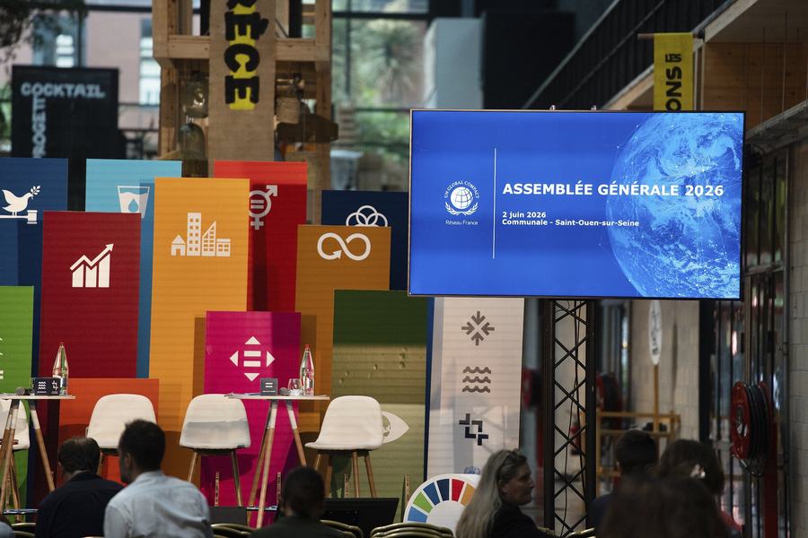 Un écran annonce l’Assemblée générale 2026 du Pacte mondial des Nations unies, Réseau France, le 2 juin 2026 à Communale, Saint-Ouen-sur-Seine, à côté de panneaux colorés des Objectifs de développement durable.